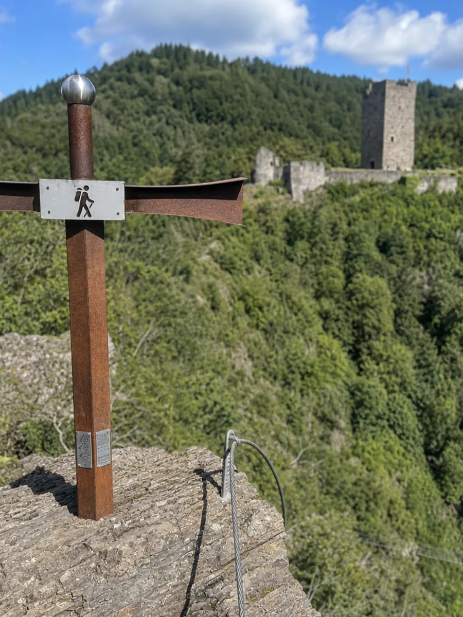Wegkreuz am Burgenklettersteig mit Blick auf den Burgturm